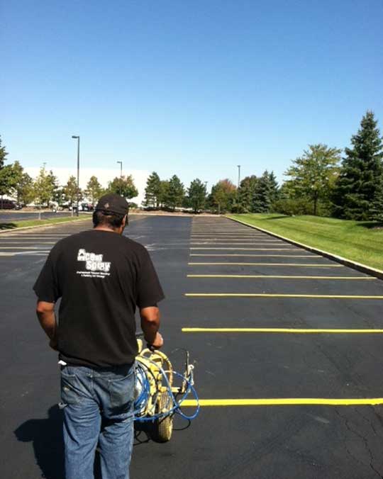 Lot-Line-Striping–Ace-of-Spray guy painting lines in a parking lot