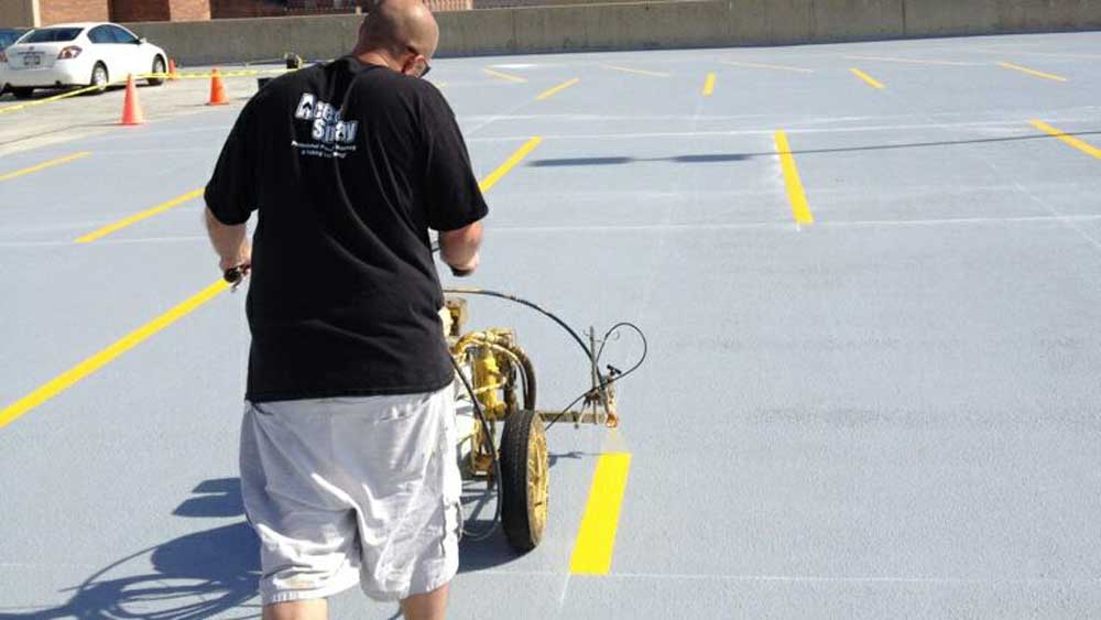 guy using a parking lot line striping machine