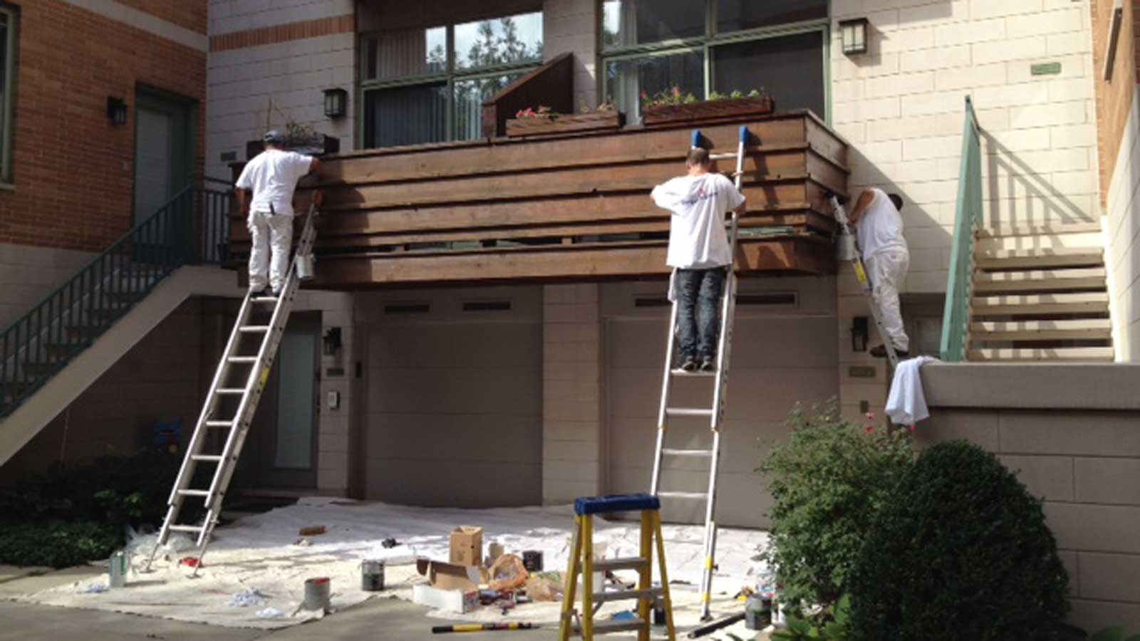 man staining a wooden deck